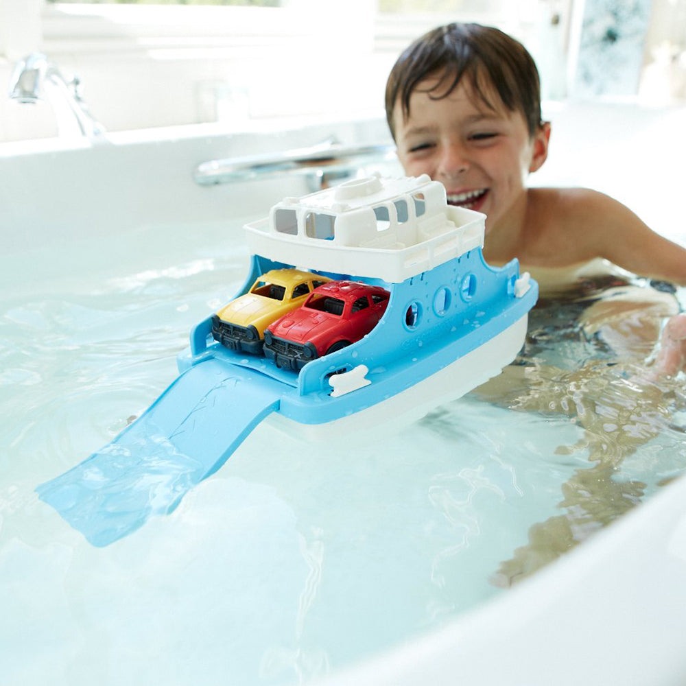 Child playing with a blue and white Green Toys Ferry Boat and two mini cars