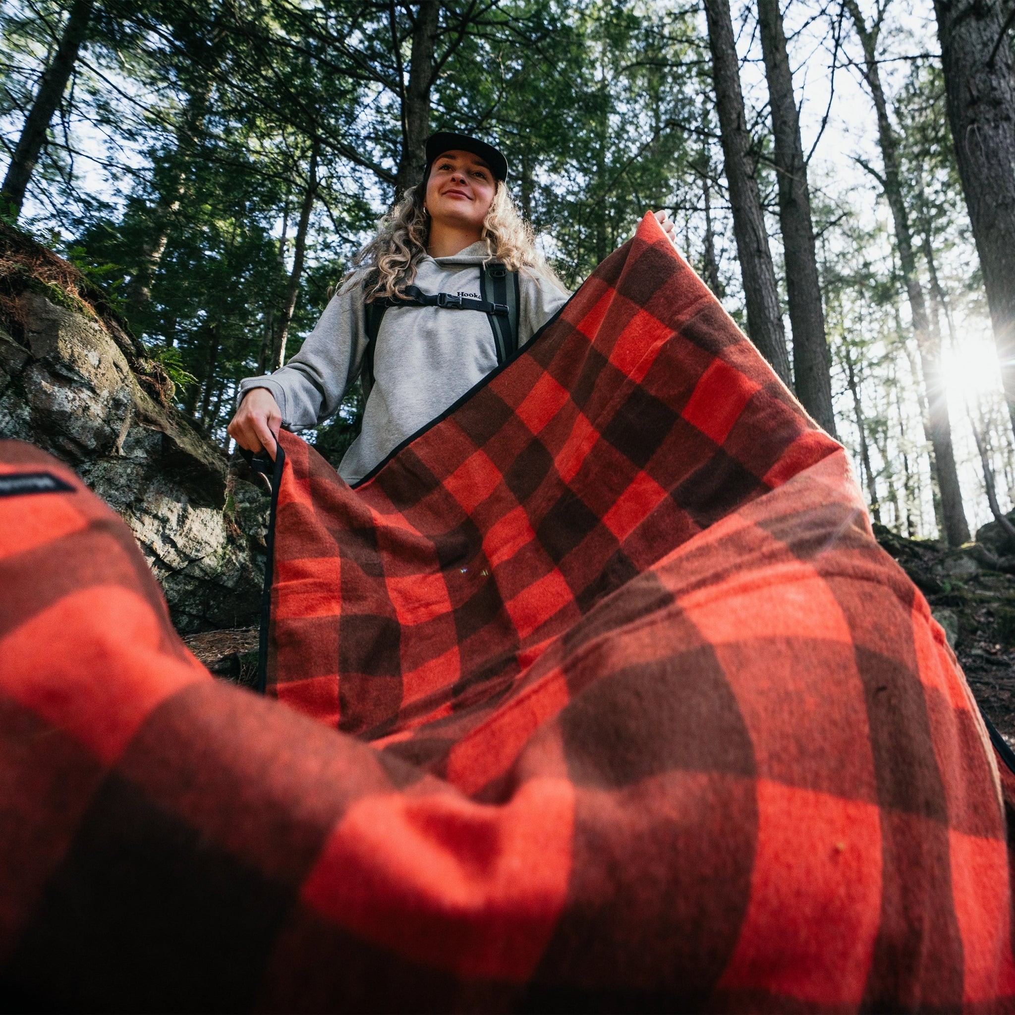 Hooké plaid outdoor blanket held up in a forest